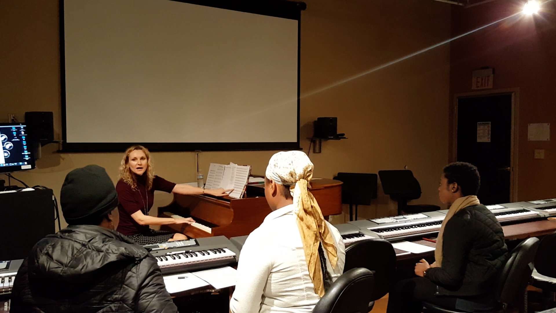 Juliana Polansky teaching a vocal class at the grand piano in a music studio
