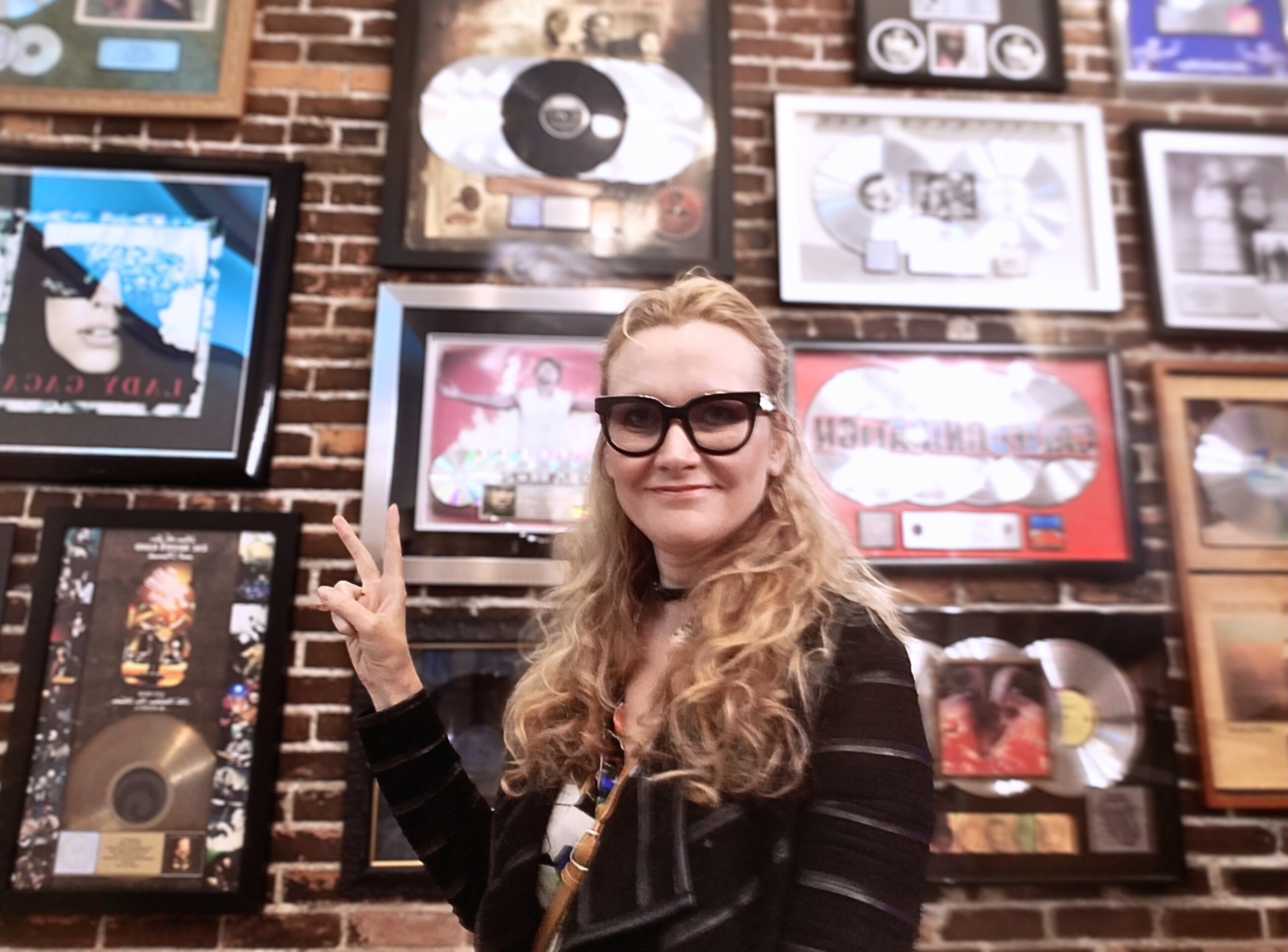 Juliana Polansky in front of a wall of framed gold and platinum records
